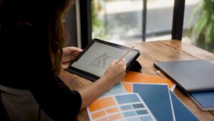 Hands sketching law firm logo designs on tablet