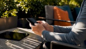 Hands holding smartphone at modern desk