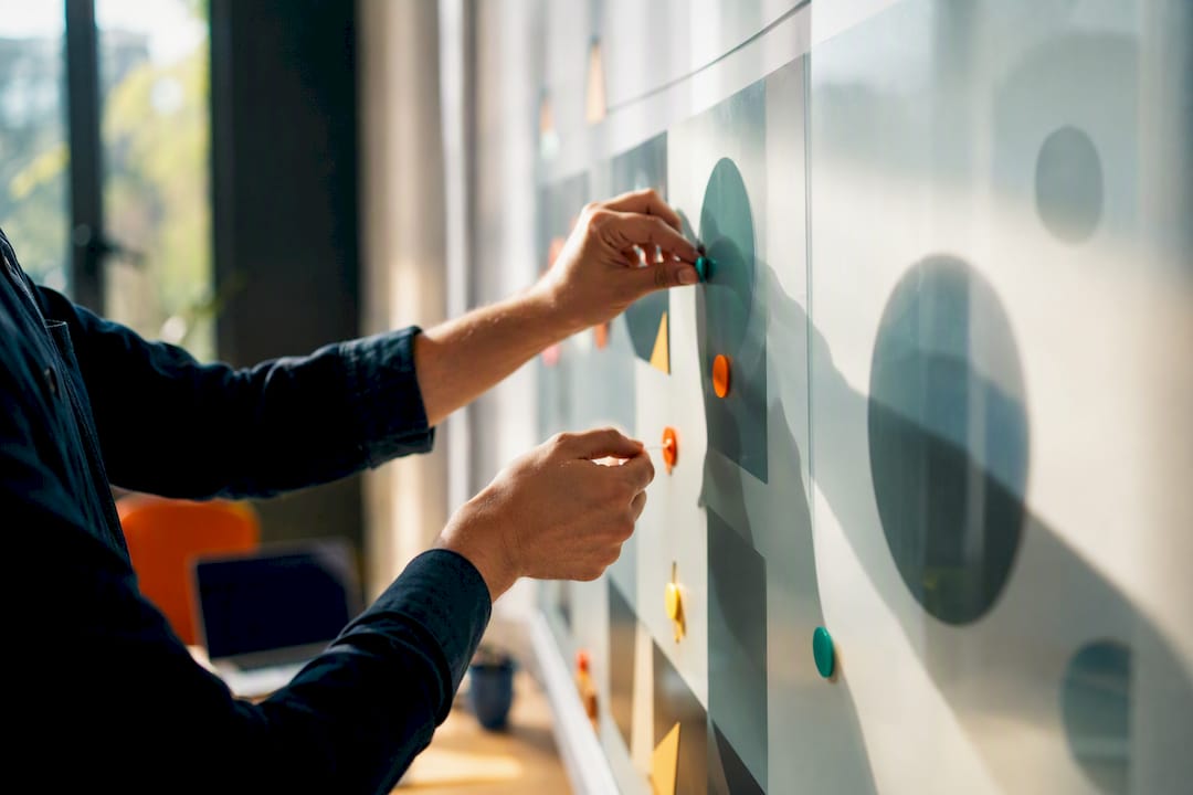 Hands arranging channel markers on glass board