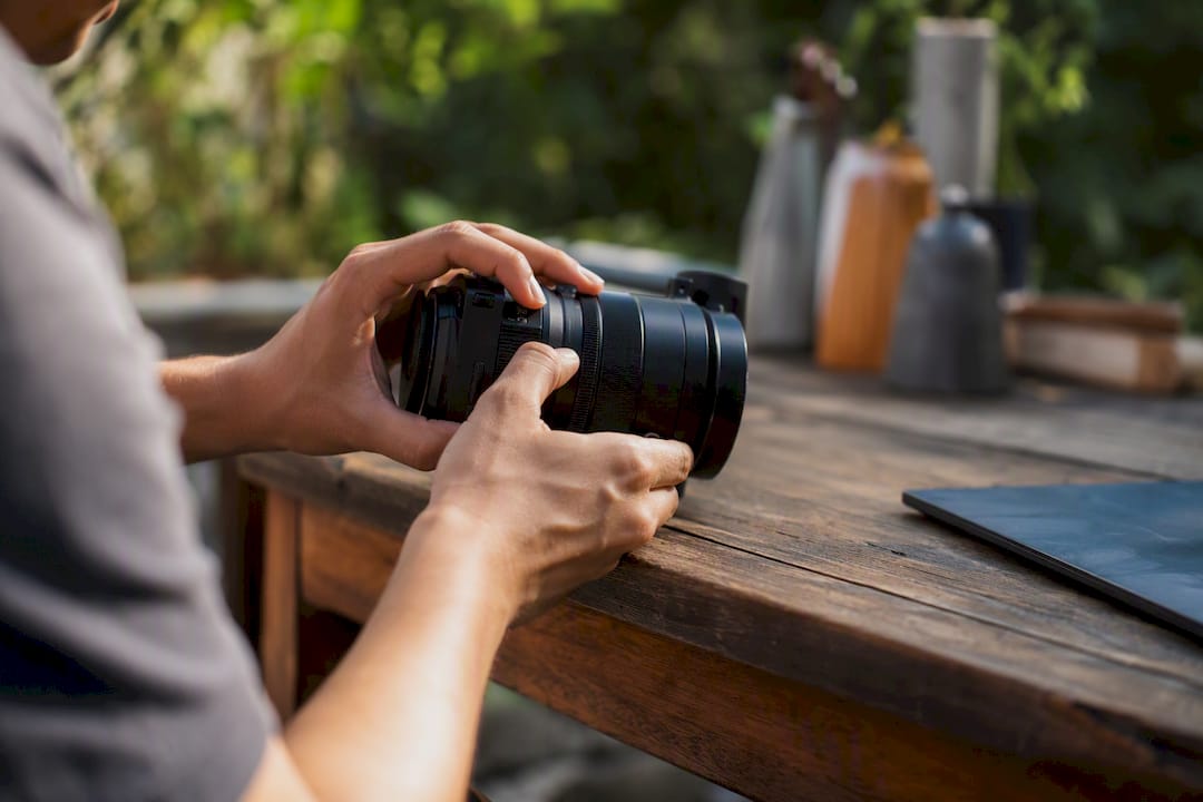 Hands adjusting camera lens in studio