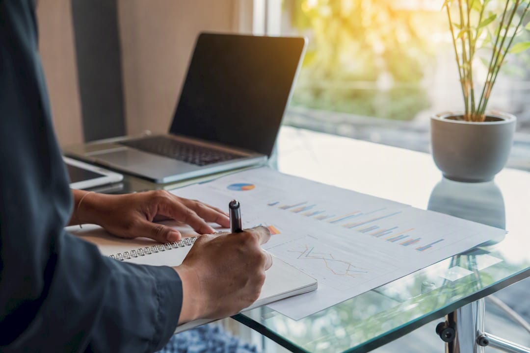 Hands annotating marketing charts with notes